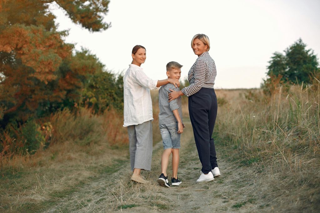 Two women walking in nature with a boy between them