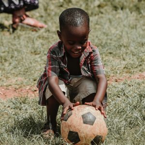 A young boy playing with a soccer ball